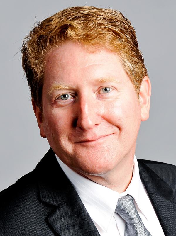 Greg Rorrer in front of a gray background