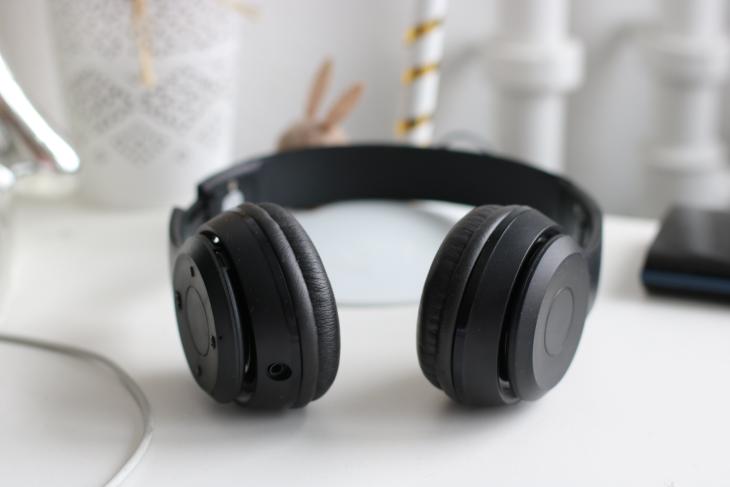 A pair of black headphones sitting on a desk